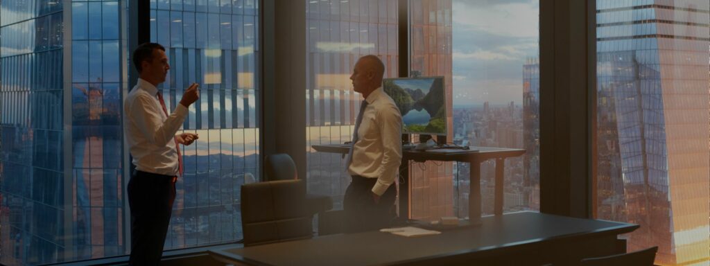 Two business men talk in an office.